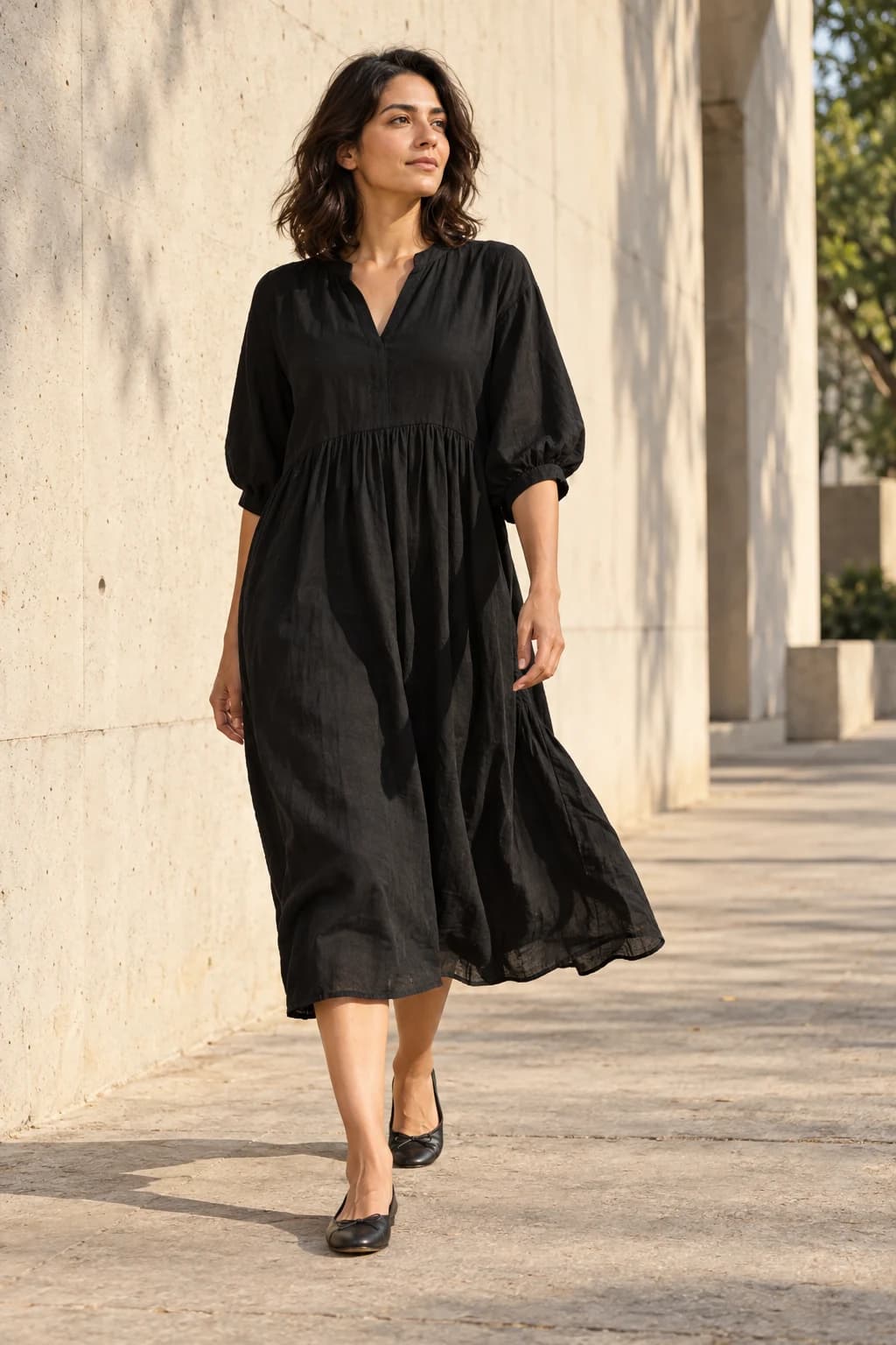 An adult model in a black midi dress. Campaign concept.