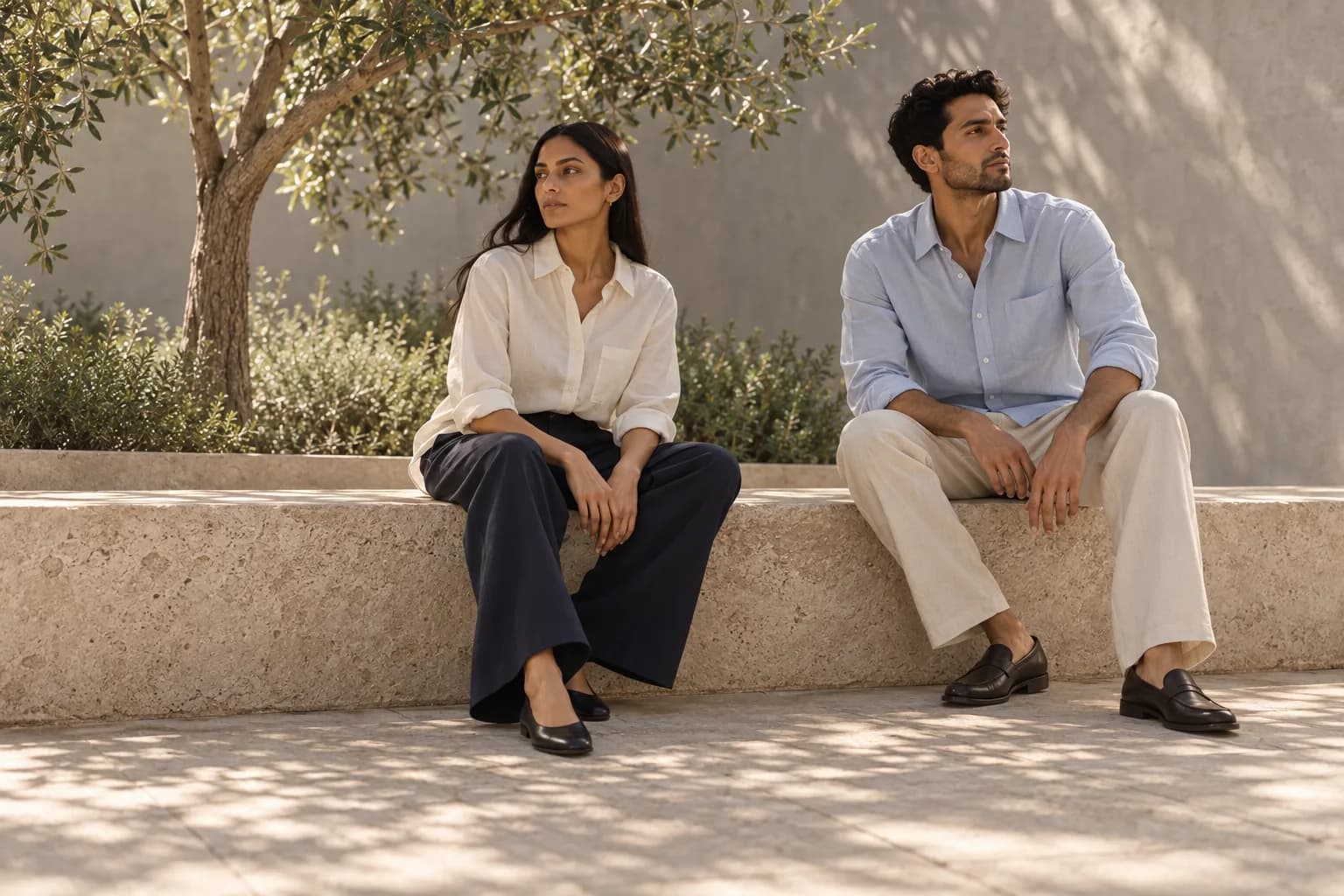 Recurring adult campaign models seated in ivory, navy, pale blue and stone separates. AI concept, not merchandise.